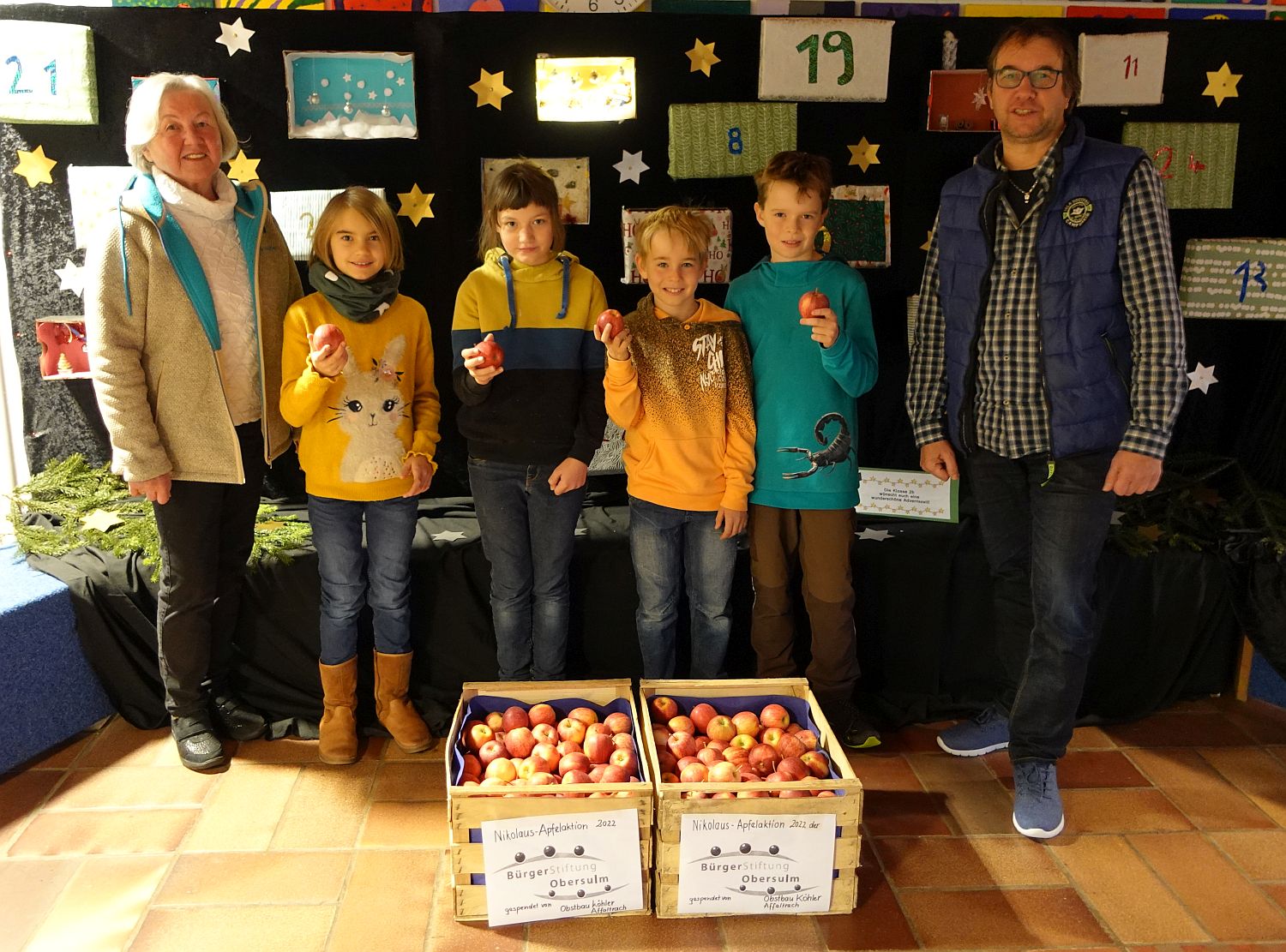 Foto mit Kindern, Rektor und Vertreterin der Bürgerstiftung mit Nikolausäpfeln